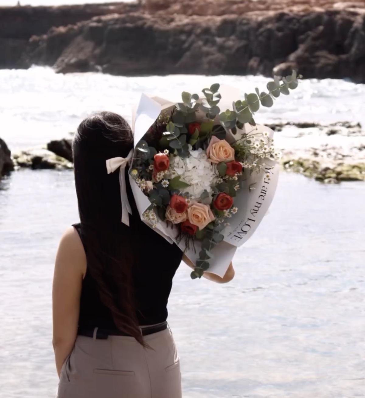 Cliente con su ramo de Las Lilas frente al mar